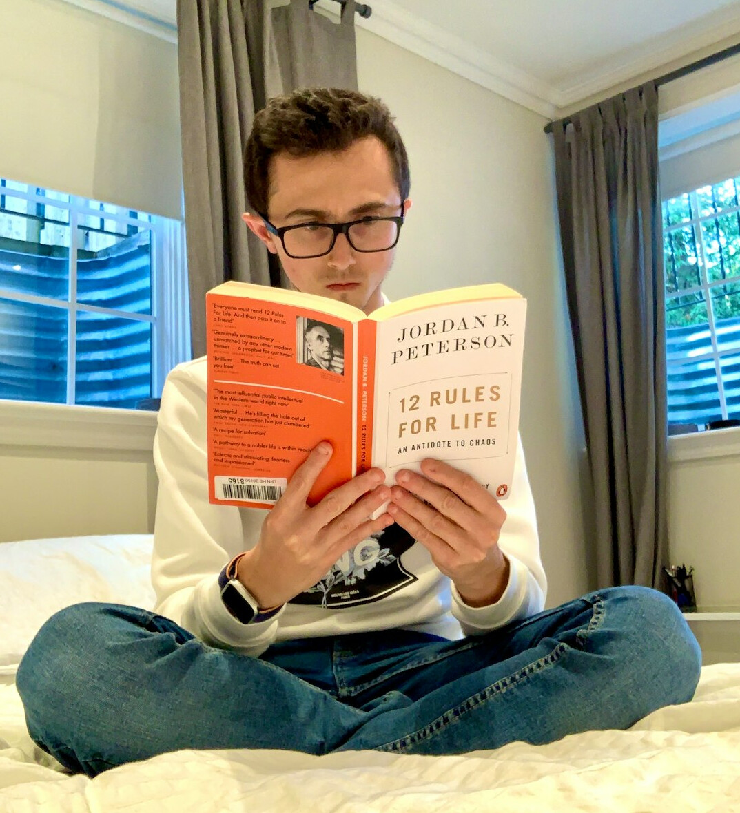 Man reading a book near a window