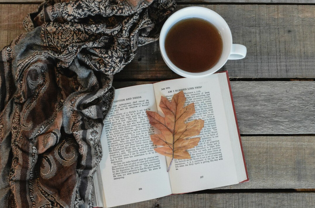 Open notebook with tea on a wooden table