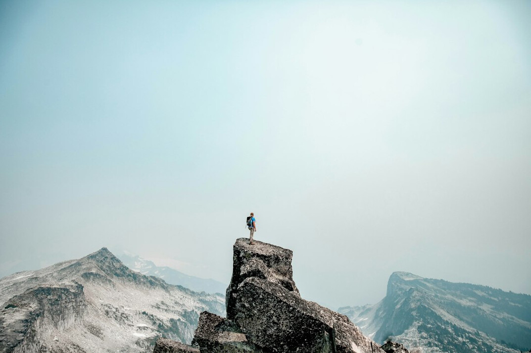 person climbing mountain of success